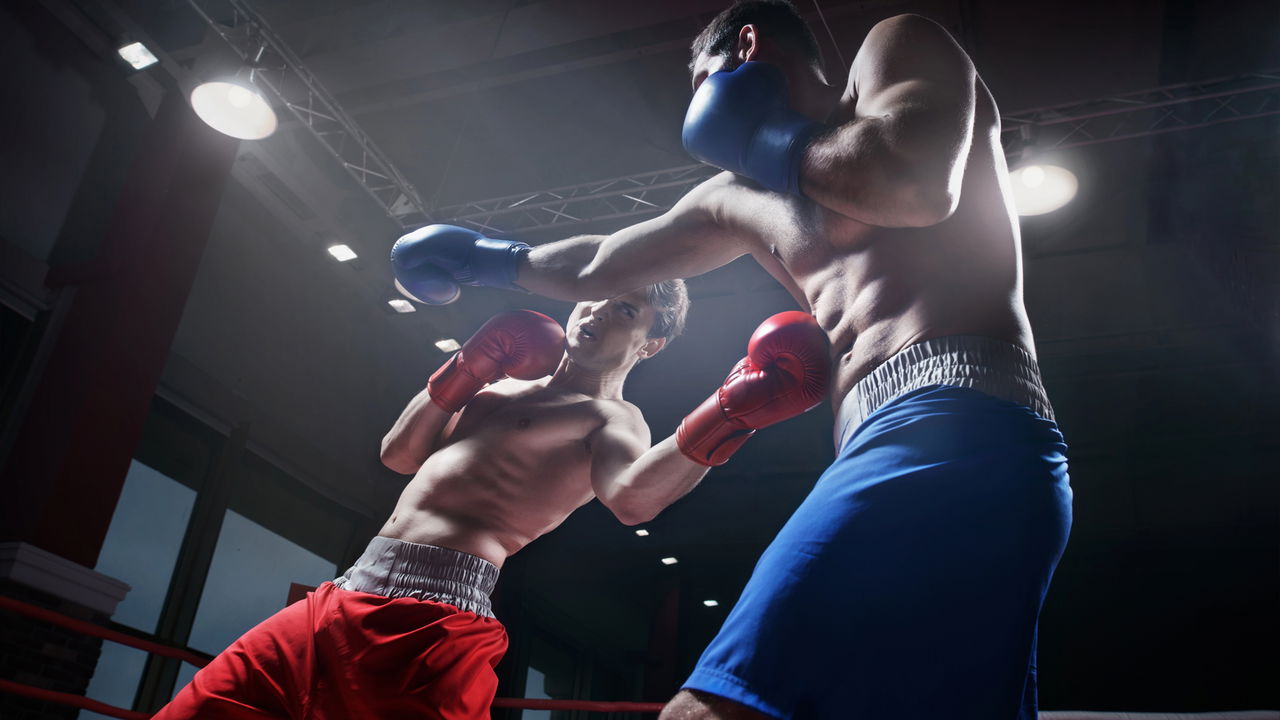 Boxeador segurando o cinturão de campeão em um ringue