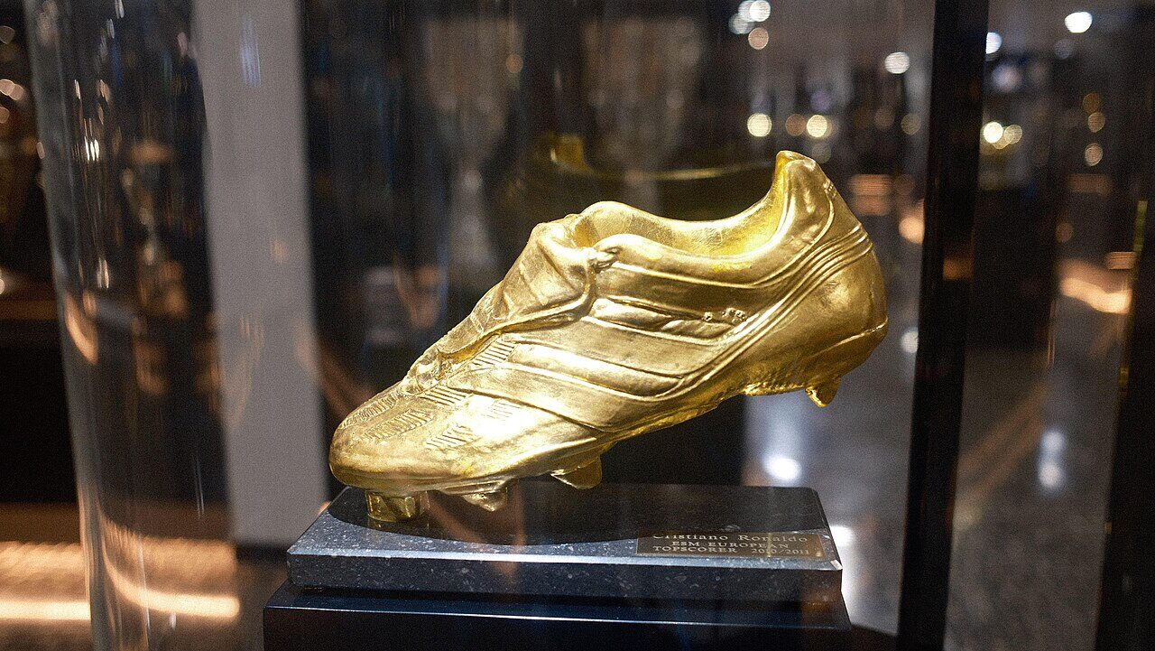 Foto de chuteiras de futebol de ouro em destaque