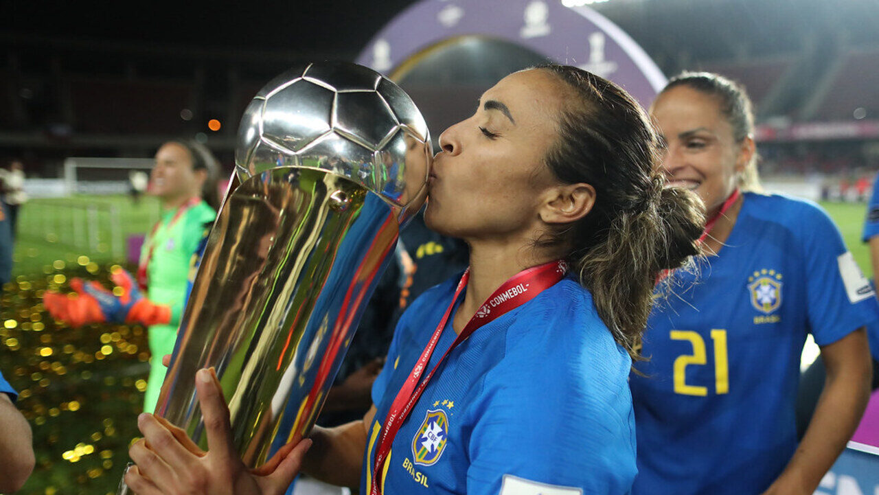 Jogadoras de futebol celebrando a conquista de um prêmio