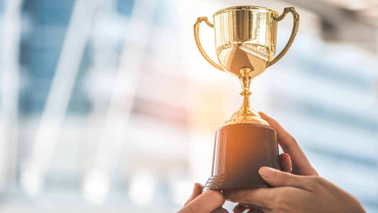 Jogador recebendo um troféu em formato de carrinho de supermercado