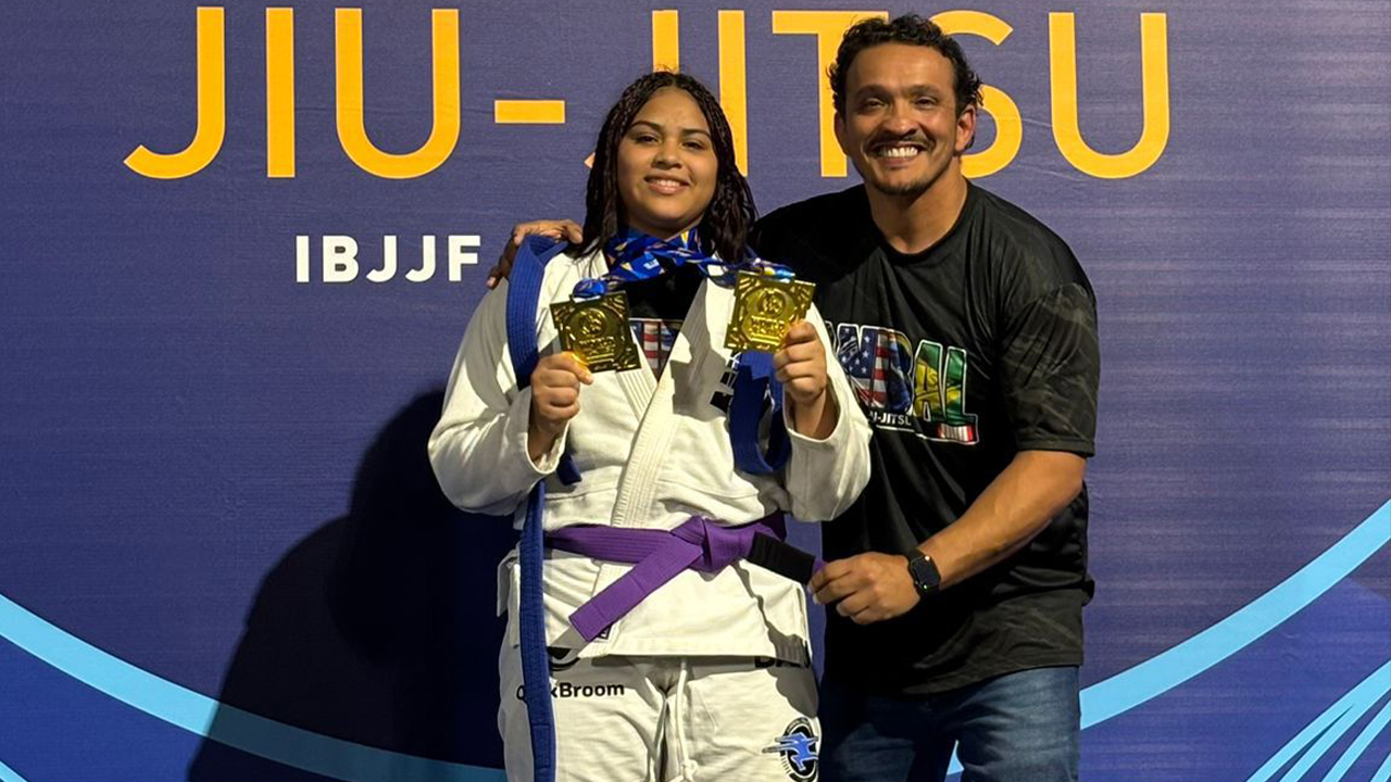 Yasmim Dounranth, campeã mundial de jiu-jitsu, recebendo a faixa-roxa de seu treinador